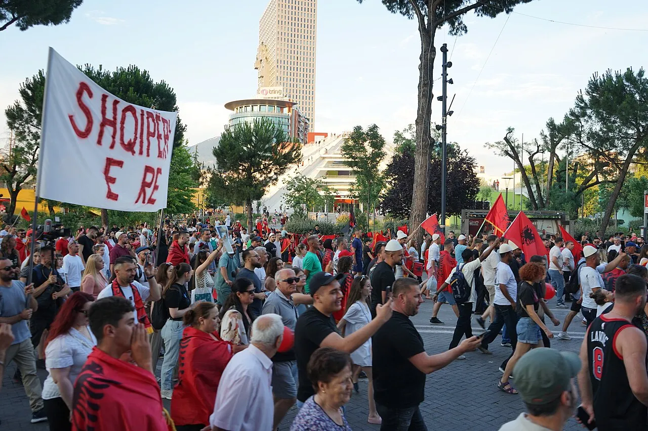 Demonstranten lopen over een boulevard in Tirana tijdens de protesten van de Flamingo-revolutie tegen de regering.